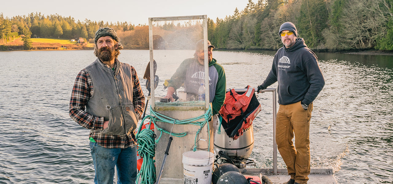 three men standing on a barge with water and land behind them