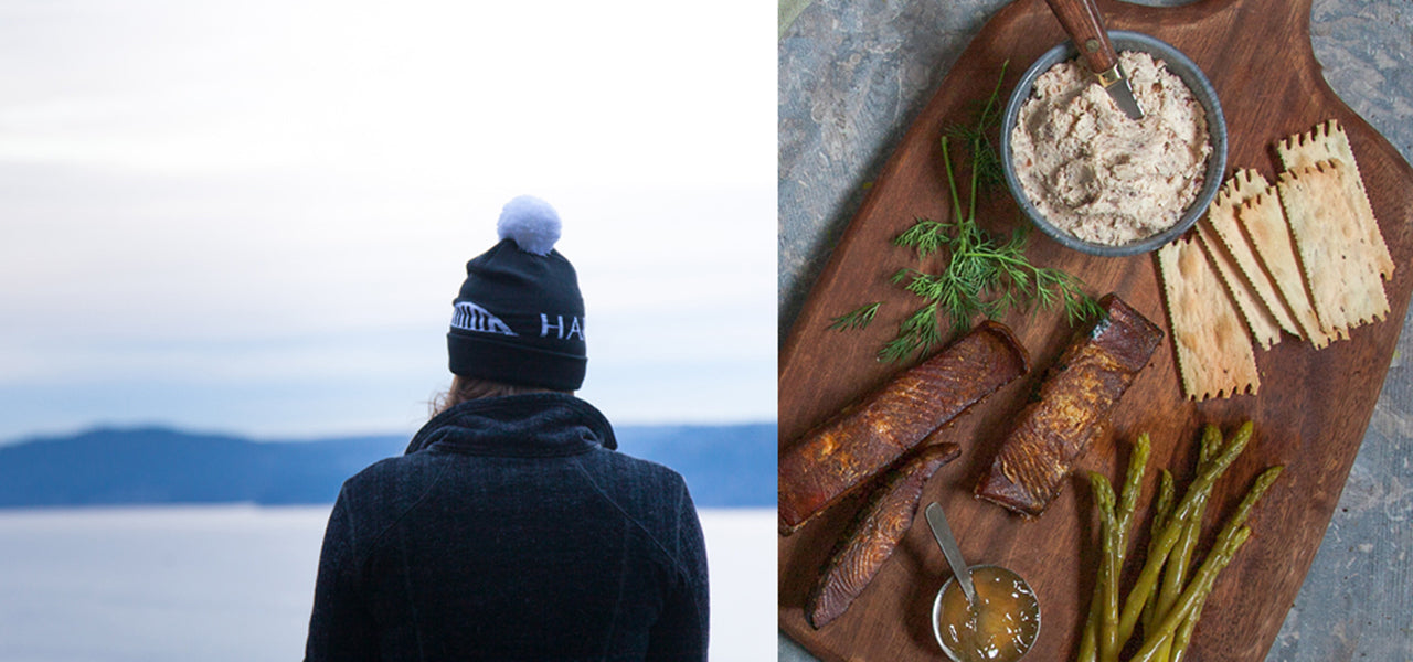 person standing facing the Hood Canal / smoked salmon, pickled vegetables, crackers and spread on a cutting board