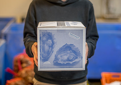 person holding a Hama Hama box for shipping